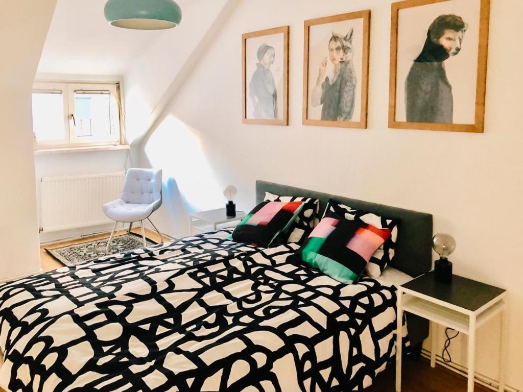 Schlafzimmer mit einem schwarzen und weißen Bett und Bildern an der Wand in der Unterkunft Cozy City Apartment - by Nahuen Suites in Graz