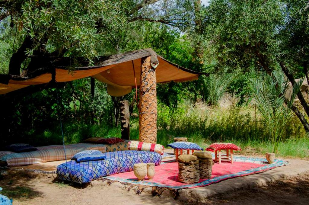 a tent with two beds with umbrellas on a blanket at Eco-Ferme Tamalait Skoura in Skoura