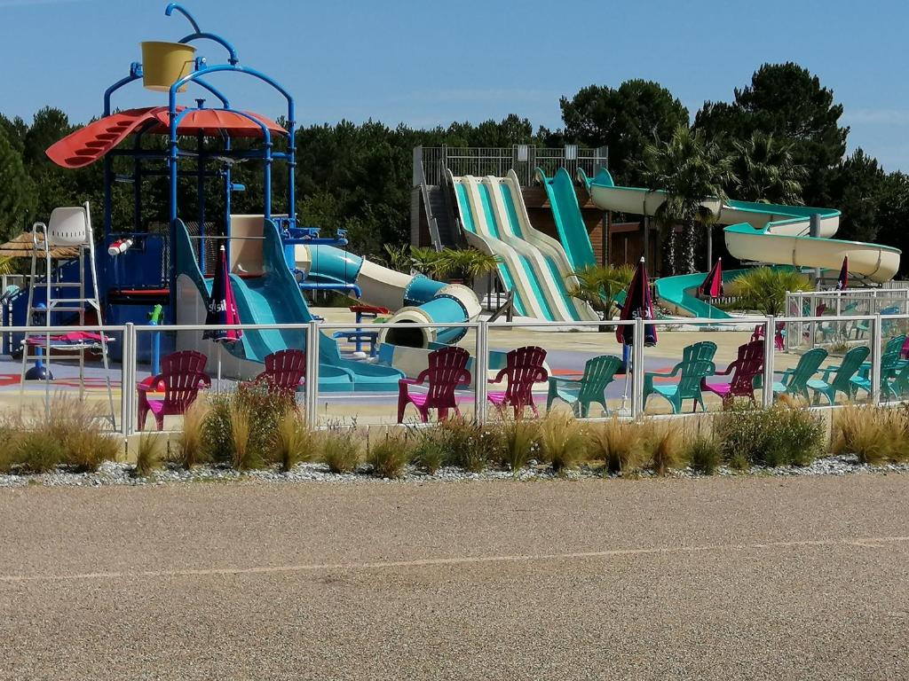 um parque infantil com um parque aquático com escorregas e cadeiras em jpp marie ange proprietaire em Saint-Julien-en-Born