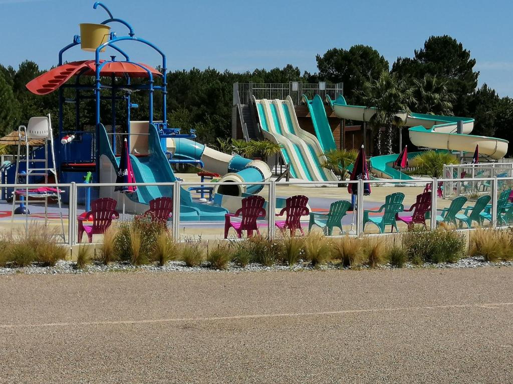 een speeltuin met een waterpark met glijbanen en stoelen bij jpp marie ange proprietaire in Saint-Julien-en-Born