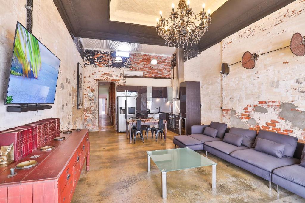 Indulge Apartments - Eighth في ميلدورا: غرفة معيشة مع أريكة وطاولة