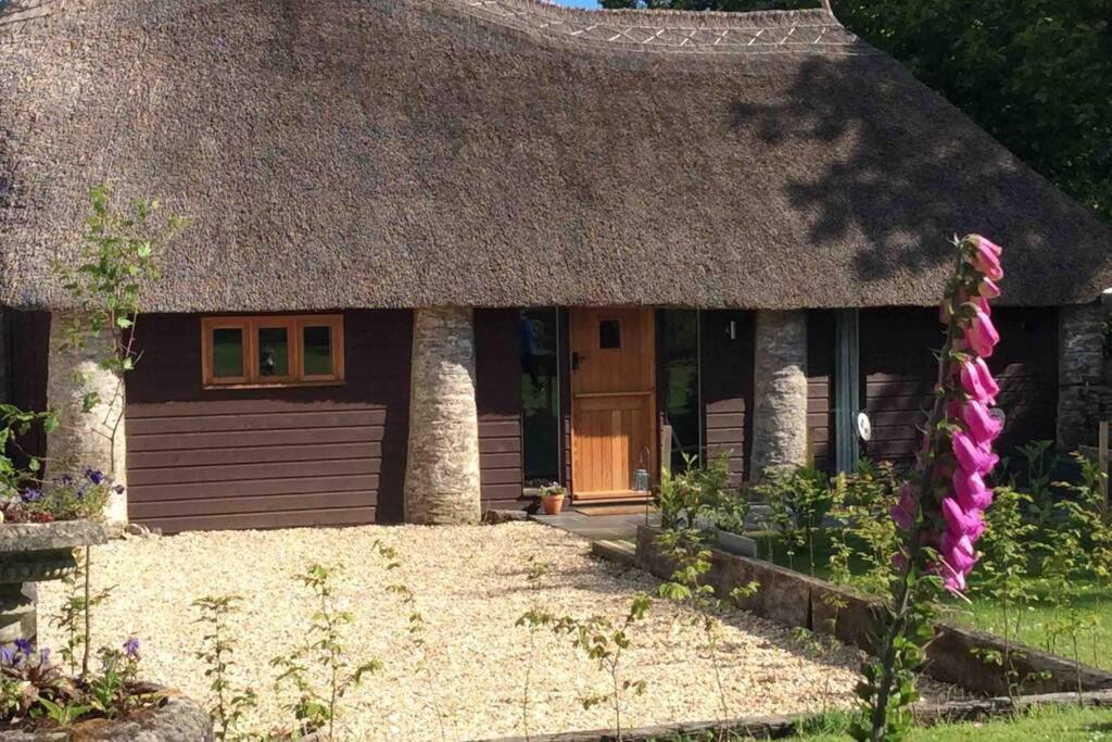 a small house with a thatched roof and a yard at Unique Thatched Retreat near Salcombe and Beaches in South Milton