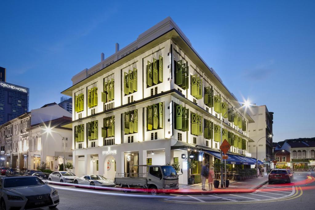 a white building with green windows on a city street at ST Signature Tanjong Pagar in Singapore