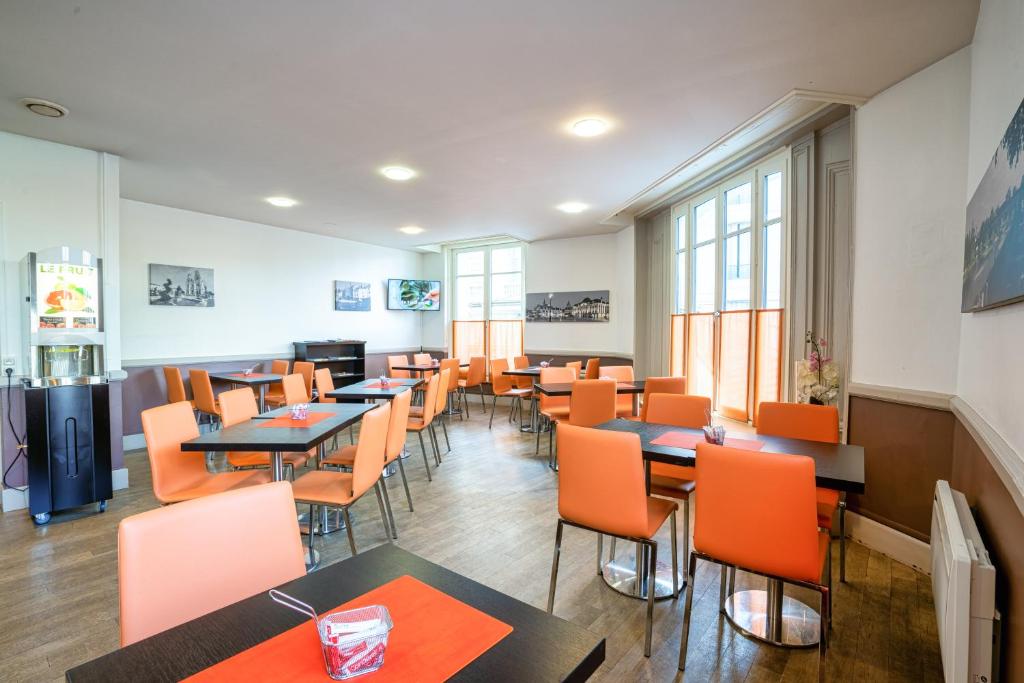 a dining room with tables and orange chairs at Campanile Orléans Centre Gare in Orléans
