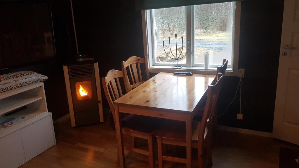 een houten tafel en stoelen in een kamer met een raam bij Romme Rum in Borlänge