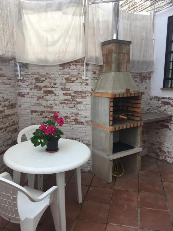 una mesa y una estufa en una habitación con una mesa y flores en Apartamento con barbacoa BBQ Los picadores, en Córdoba