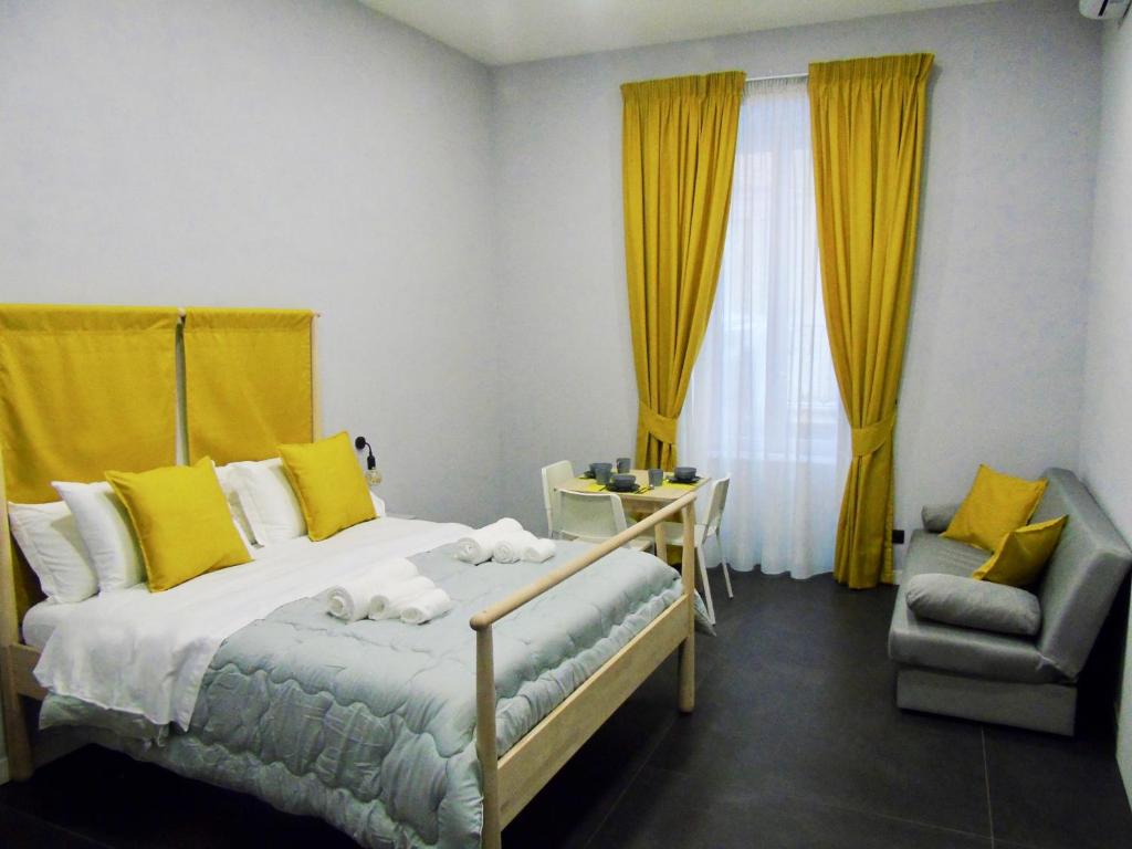 a bedroom with a bed and a chair and a window at Cabà bed&breakfast in Naples