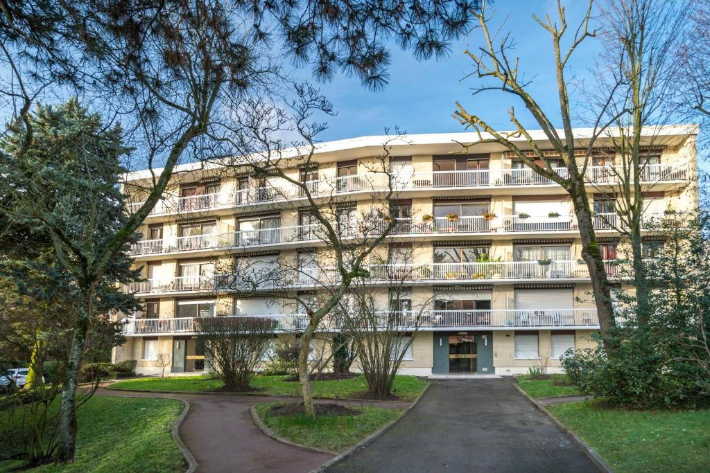 un immeuble d'appartements avec des arbres devant dans l'établissement Résidence du Parc, à Fontenay-aux-Roses