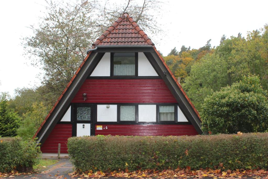 ein rotes Haus mit spitzem Dach in der Unterkunft Ferienhaus Mohnblume in Ronshausen