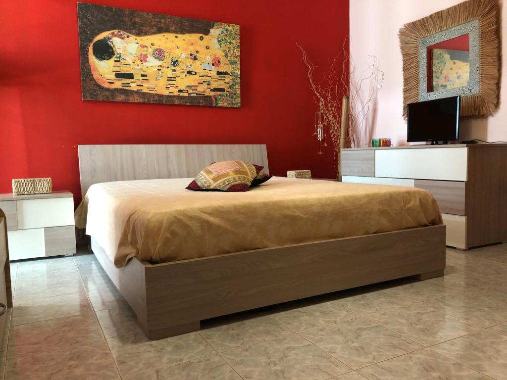 Baia Di GallipoliにあるGallipoli Baia Verdeの赤い壁のベッドルーム1室(ベッド1台付)