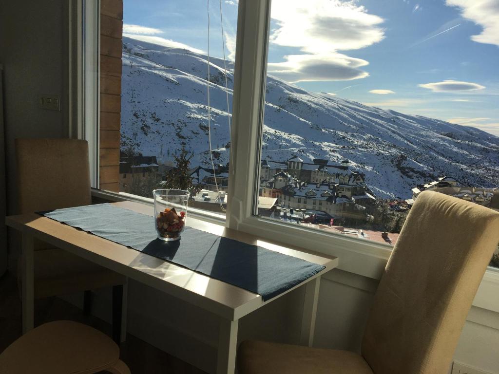 uma janela com uma mesa e vista para uma montanha em Sierra Nevada em Sierra Nevada