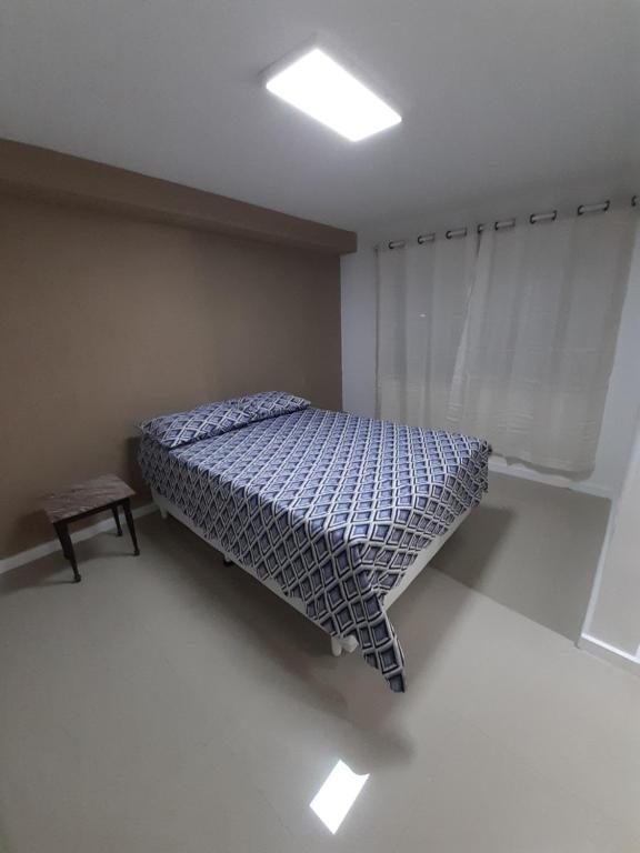 Habitación pequeña con cama y ventana en Casa Itapuca, en Niterói