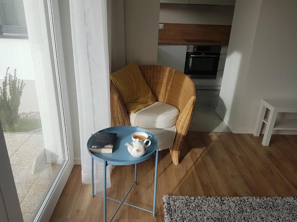 una mesa con una silla y una taza de café. en Apartament Jasińskiego z ogrodem, en Piaseczno