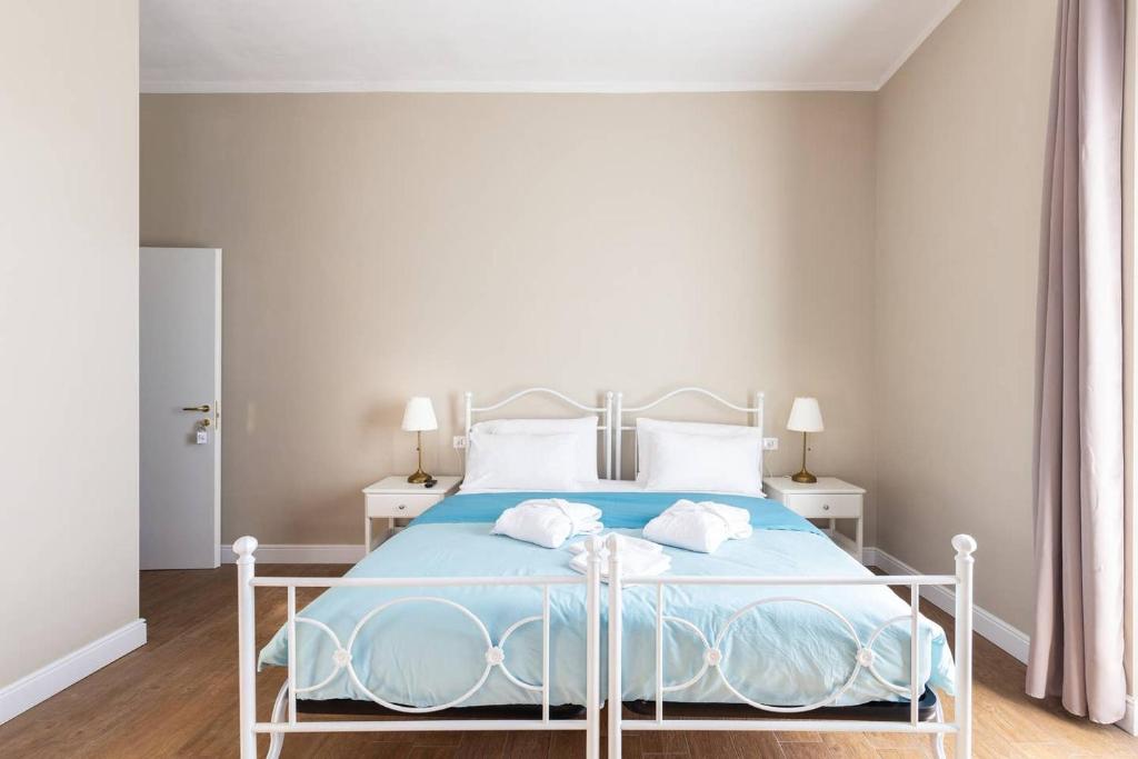 a bedroom with a bed with blue sheets and white pillows at Casa Aydée in Bergamo