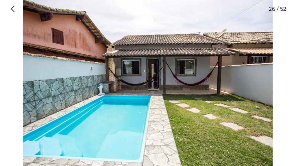 a pool in the backyard of a house at Casa com piscina, wifi e churrasqueira em unamar. in Tamoios