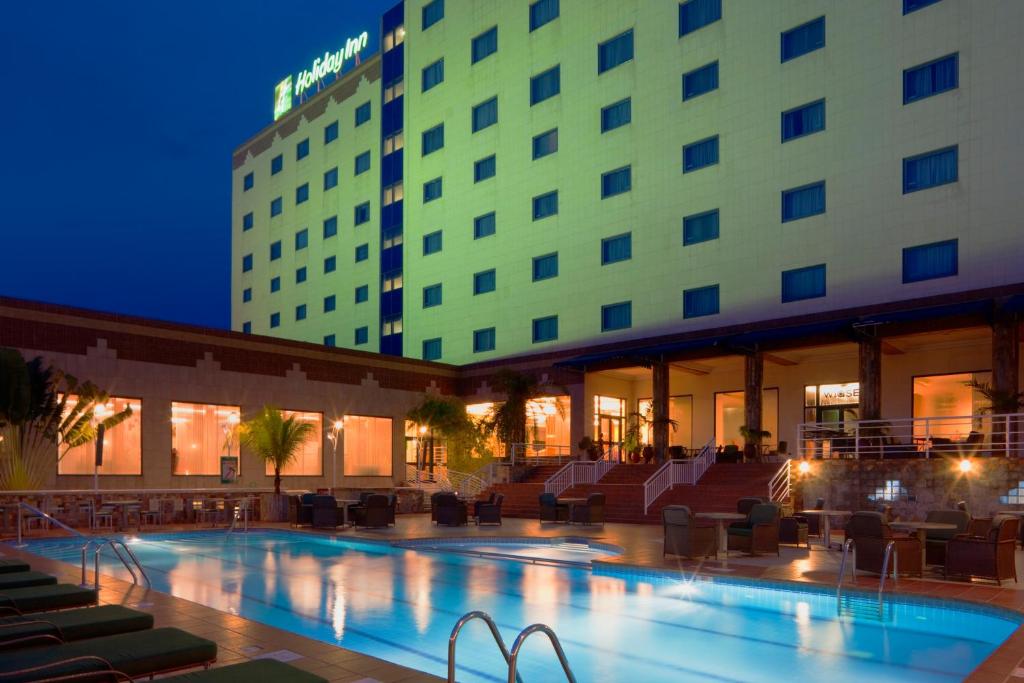 a hotel with a swimming pool in front of a building at Holiday Inn Accra Airport, an IHG Hotel in Accra