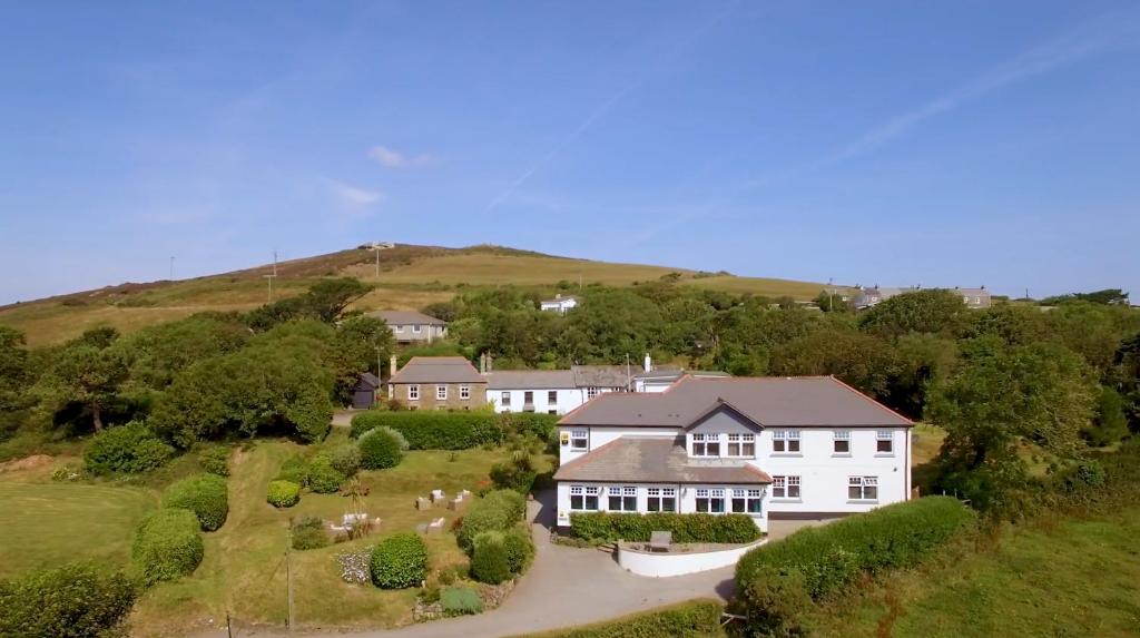 an aerial view of a large white house on a hill at Beacon Country House Hotel & Luxury Shepherd Huts in St. Agnes