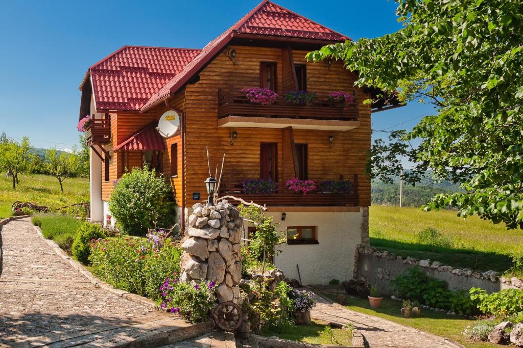 uma casa de madeira com um telhado vermelho em House Mrzlin Grad em Korenica