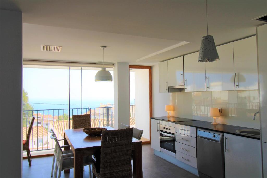 a kitchen with a table and a view of the ocean at Hostal Fornet Altea in Altea
