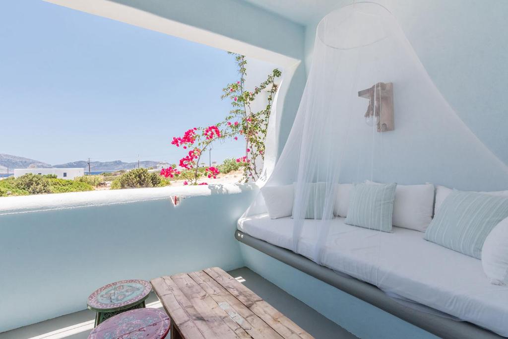a white room with a bench and a window at Pangaia Seaside Ηotel Adults Only in Koufonisia
