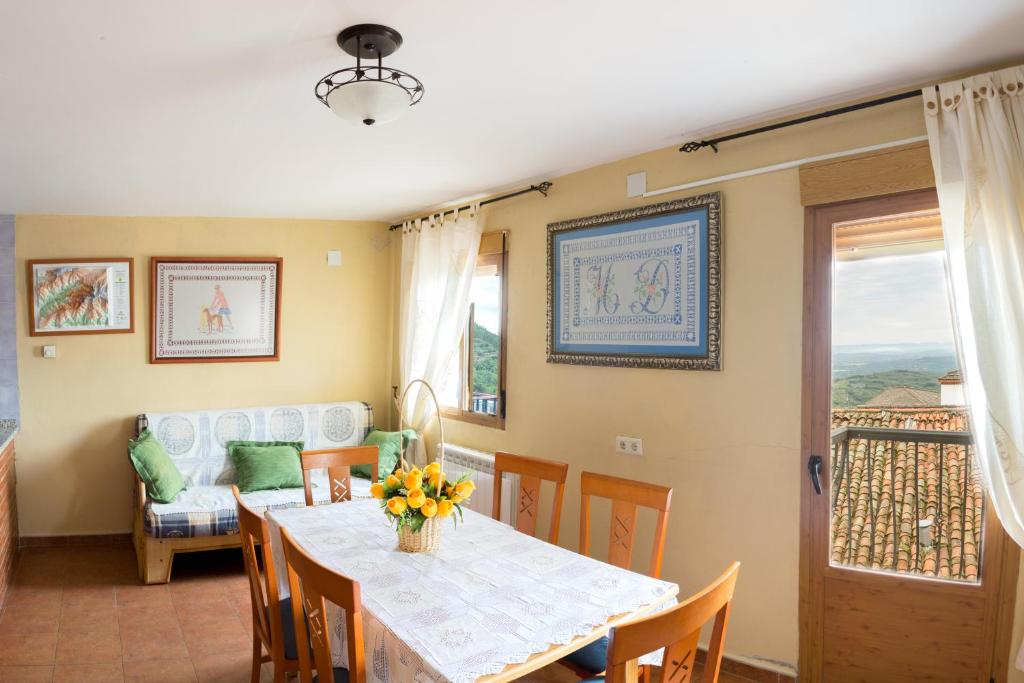 Un comedor con una mesa y un sofá. en Las Calabazas, en Barrado
