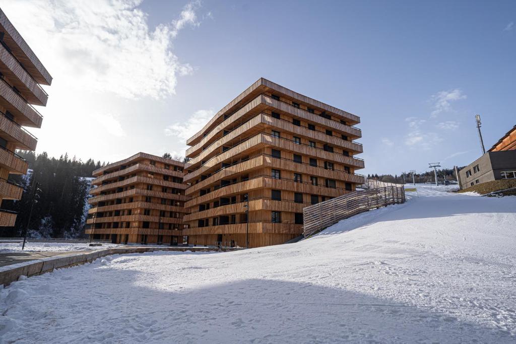 twee hoge gebouwen in de sneeuw voor een gebouw bij Edelweiss Stenna Cavorgia in Flims