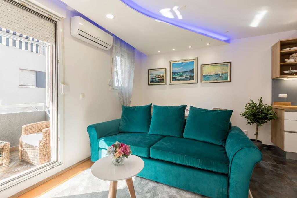 uma sala de estar com um sofá azul e uma mesa em Noemi Luxury Apartment em Solin