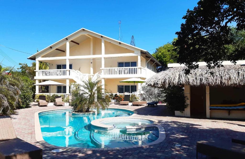 a resort with a swimming pool in front of a building at Wayaca Mini Resort in Willemstad