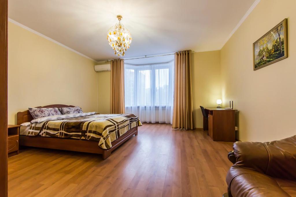 1 dormitorio con 1 cama y 1 sofá en Комфортная двухкомнатная квартира возле метро Академгородок, en Kiev