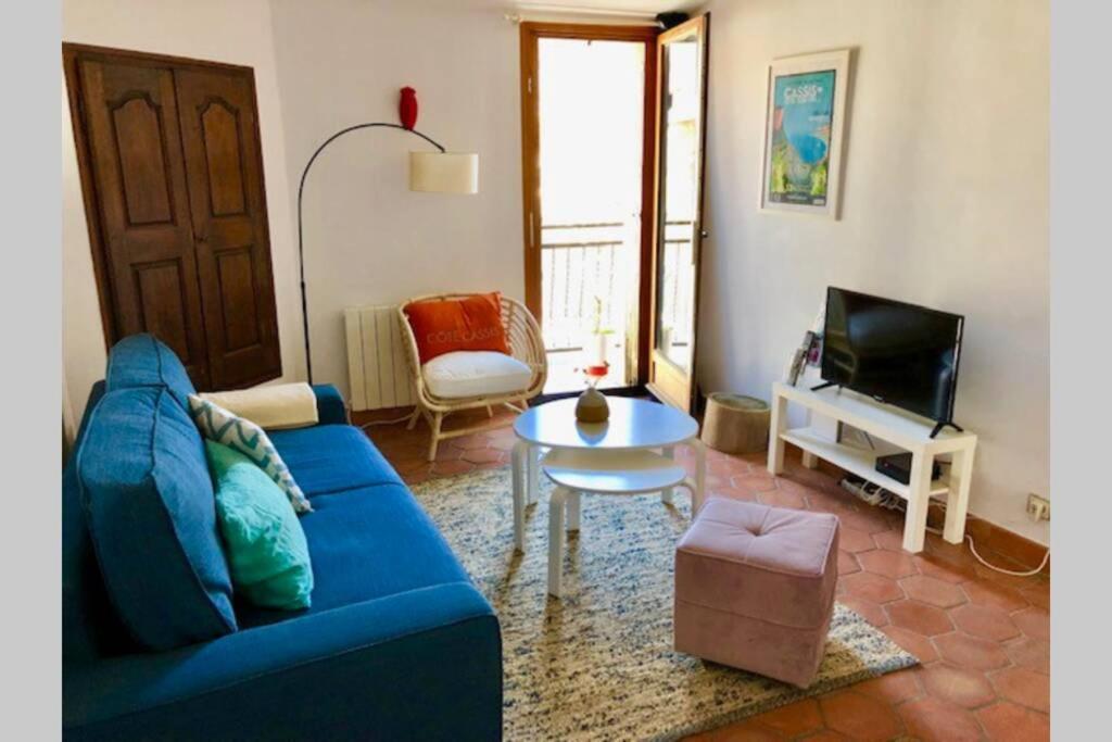 a living room with a blue couch and a tv at DUPLEX EN PLEIN COEUR DU VILLAGE in Cassis
