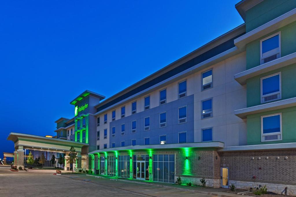 un edificio con luces verdes en el lateral. en Holiday Inn - Amarillo East, an IHG Hotel en Amarillo