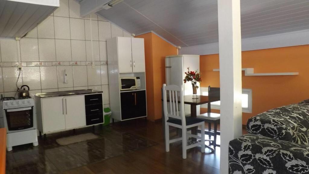 cocina y comedor con mesa, cocina y habitación en Lago do Bosque, en Gramado