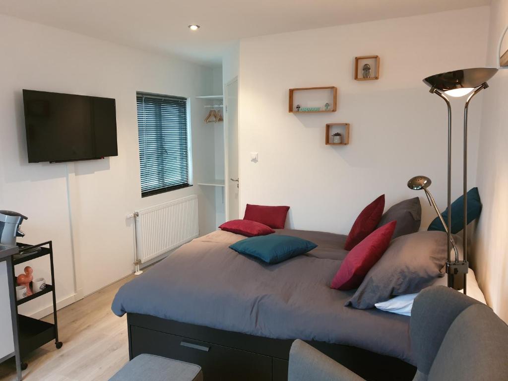 a bedroom with a large bed with red and blue pillows at Sunset Lodge in Zandvoort