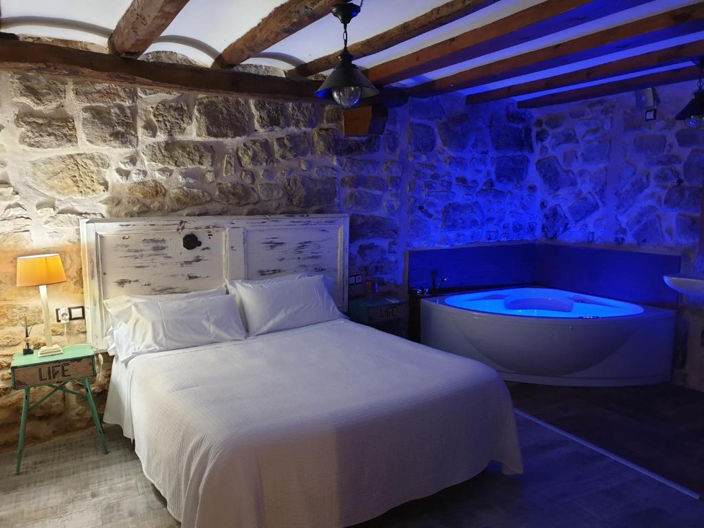 1 dormitorio con cama y bañera en El Racó de Valderrobres, en Valderrobres