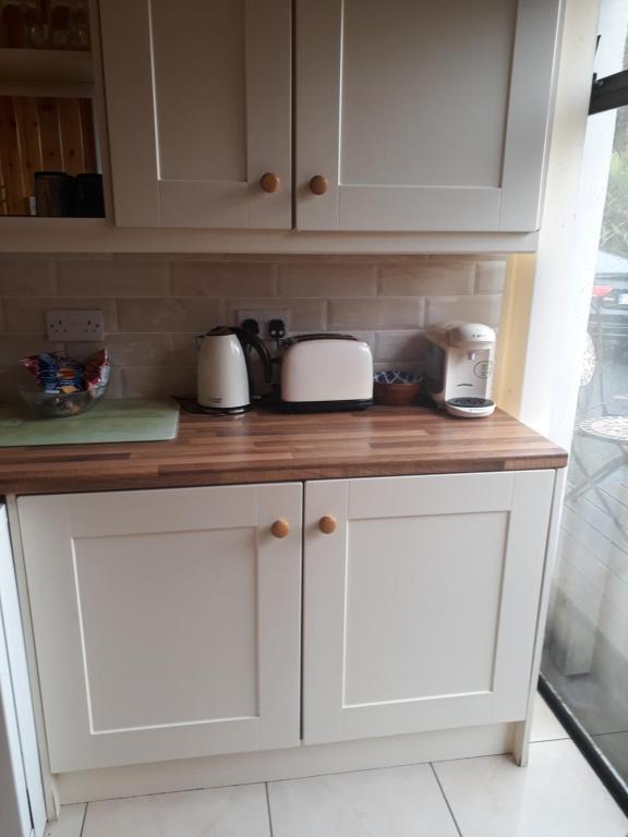 a kitchen counter with white cabinets and appliances on it at Apartment in the Heart of Kerry in Knockeen Cross Roads