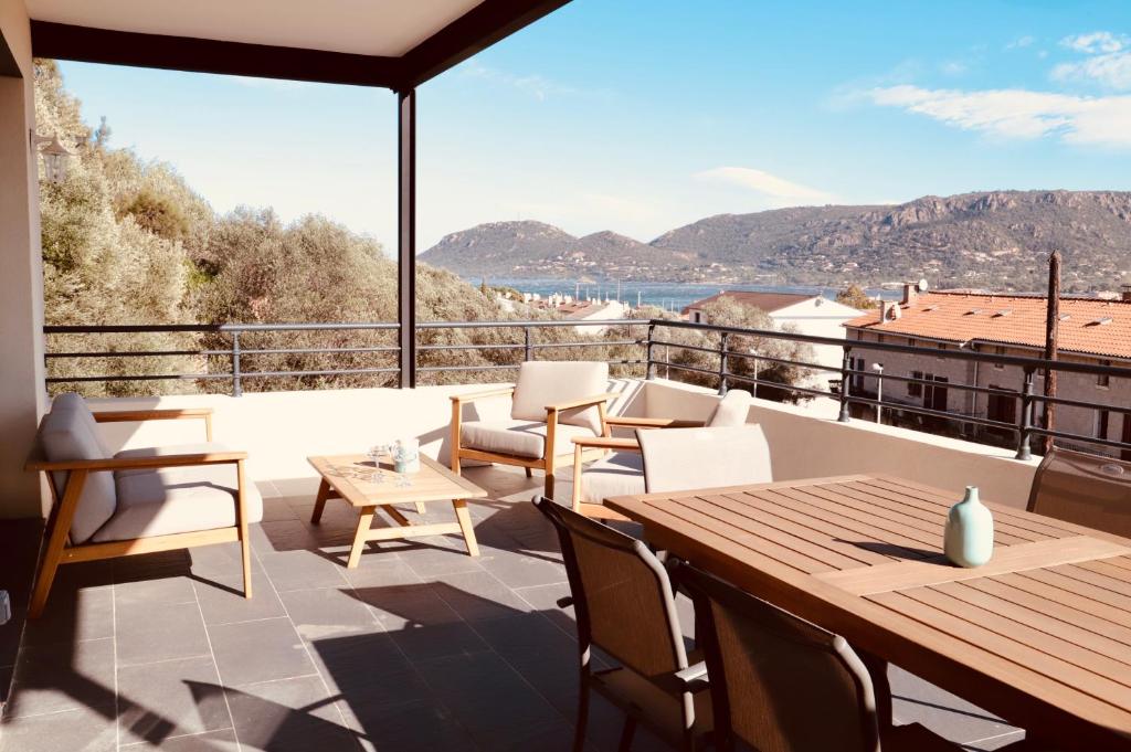 een patio met een tafel en stoelen op een balkon bij Très bel appartement avec grande terrasse in Porto-Vecchio