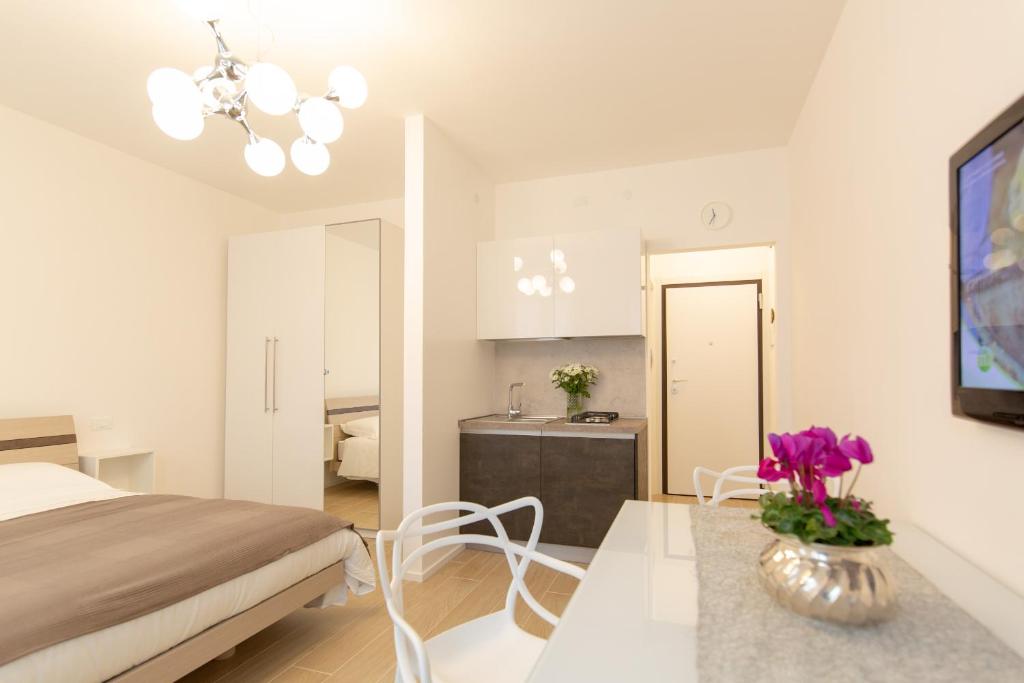 een slaapkamer met een bed en een tafel met een vaas met paarse bloemen bij " CASA IDA " centro storico in Padua