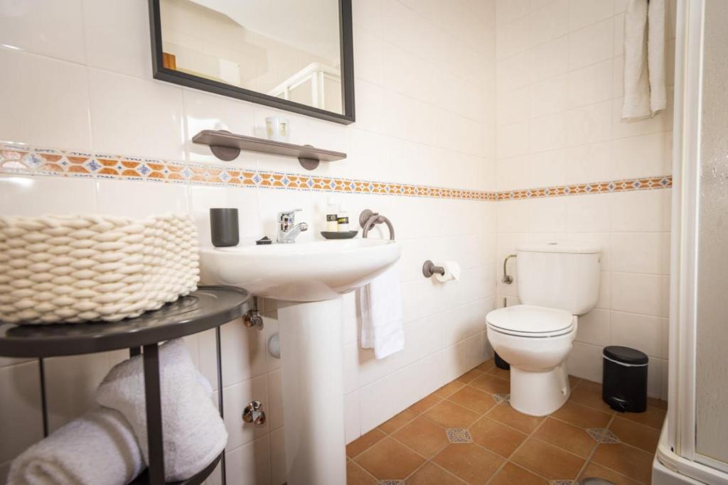 a bathroom with a sink and a toilet at Apartamentos Pumarin in Santa Marina