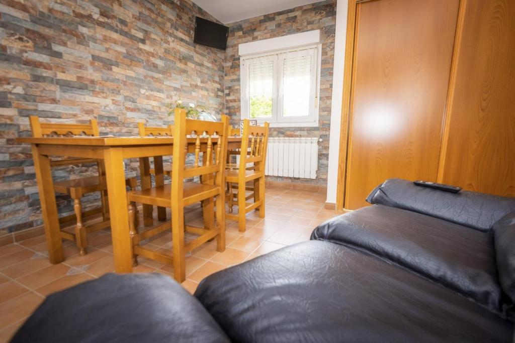 a living room with a table and chairs and a couch at Apartamentos Pumarin in Santa Marina