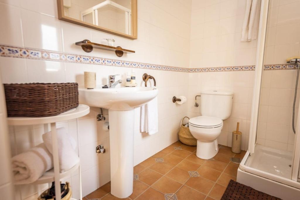 a bathroom with a sink and a toilet at Apartamentos Pumarin in Santa Marina