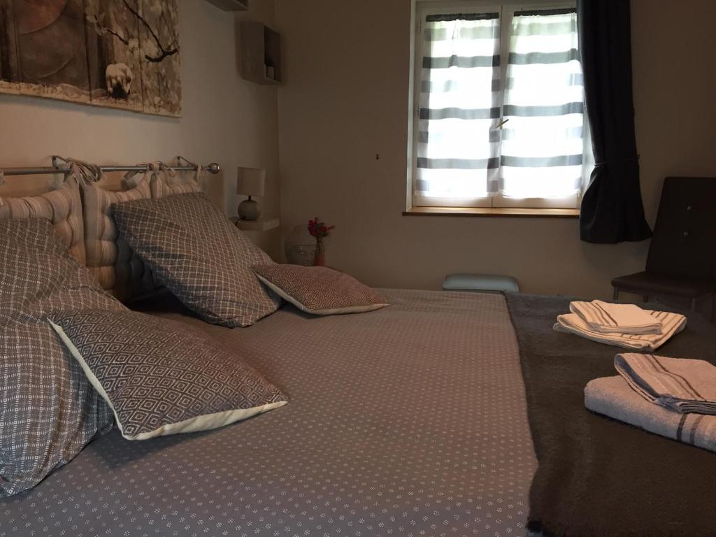 sypialnia z 2 łóżkami z poduszkami i oknem w obiekcie la ferme des ruelles w mieście Moigny