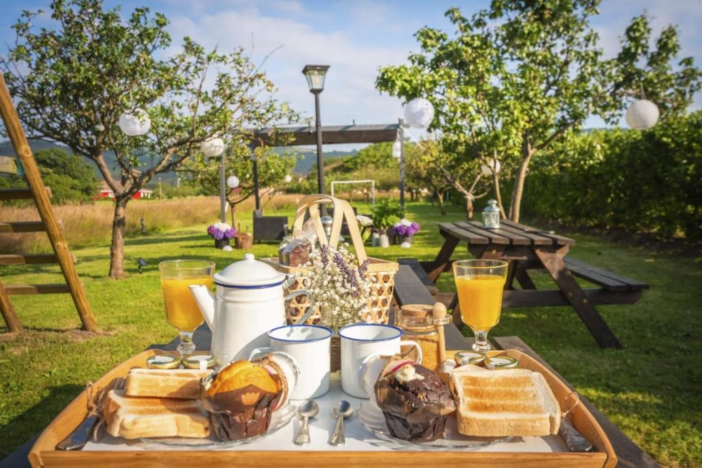 a picnic table with breakfast foods and drinks on it at Apartamentos Pumarin in Santa Marina