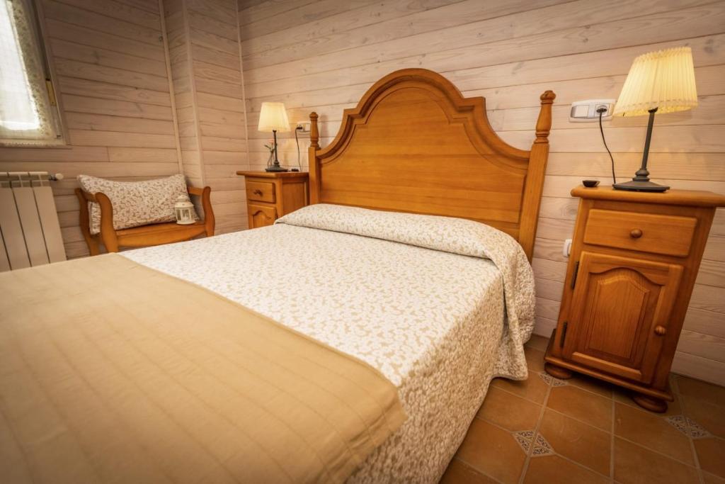 a bedroom with a bed and a lamp and a chair at Apartamentos Pumarin in Santa Marina