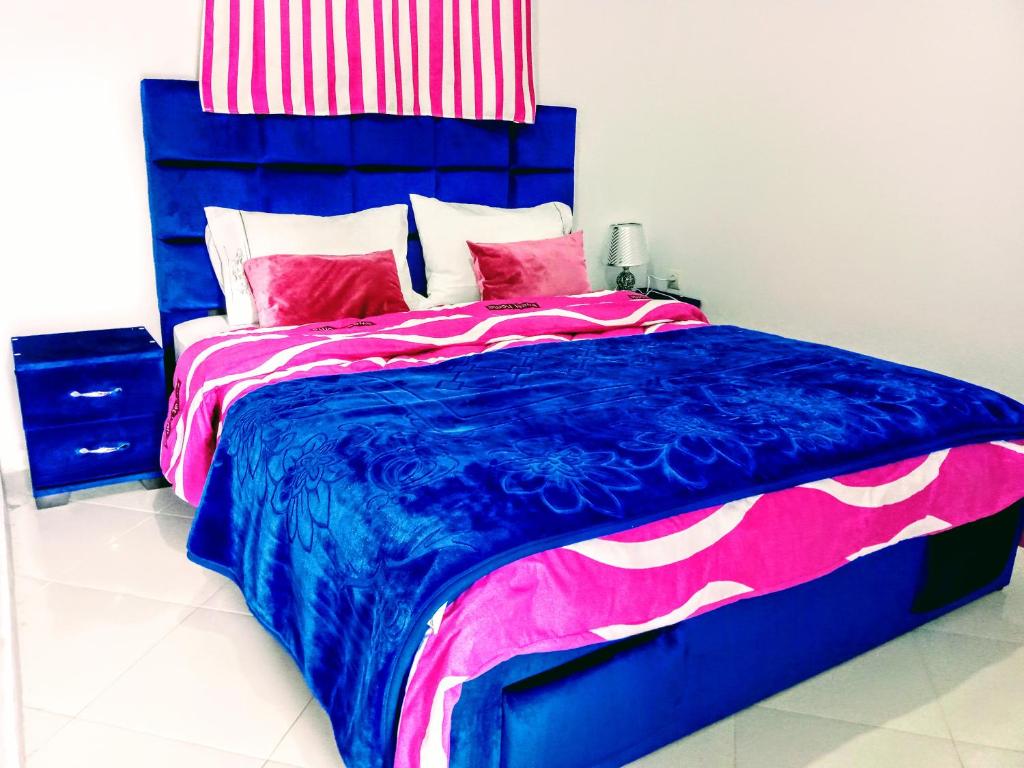 - une chambre avec un lit et une couette bleue et rose dans l'établissement Gite Karine, à Imouzzer du Kandar