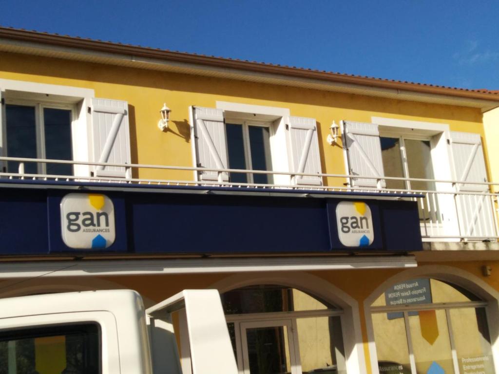een geel gebouw met een balkon erboven bij logis SAINT AUSTREMOINE in Issoire