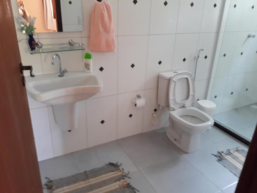 a bathroom with a sink and a toilet at Recanto Verde - Praia de Santo Antônio in Diogo