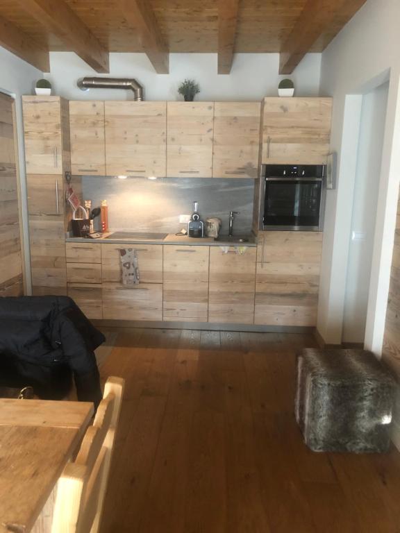 uma cozinha com armários de madeira e um forno com placa de fogão em Monolocale di charme a due passi da courmayeur em Pré-Saint-Didier