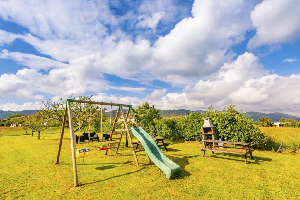 a playground with a slide in a field at Apartamentos Pumarin in Santa Marina