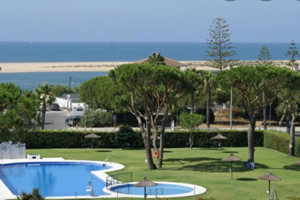 um resort com duas piscinas e árvores e uma praia em Arabia`s Loft II Nuevo Portil em El Portil