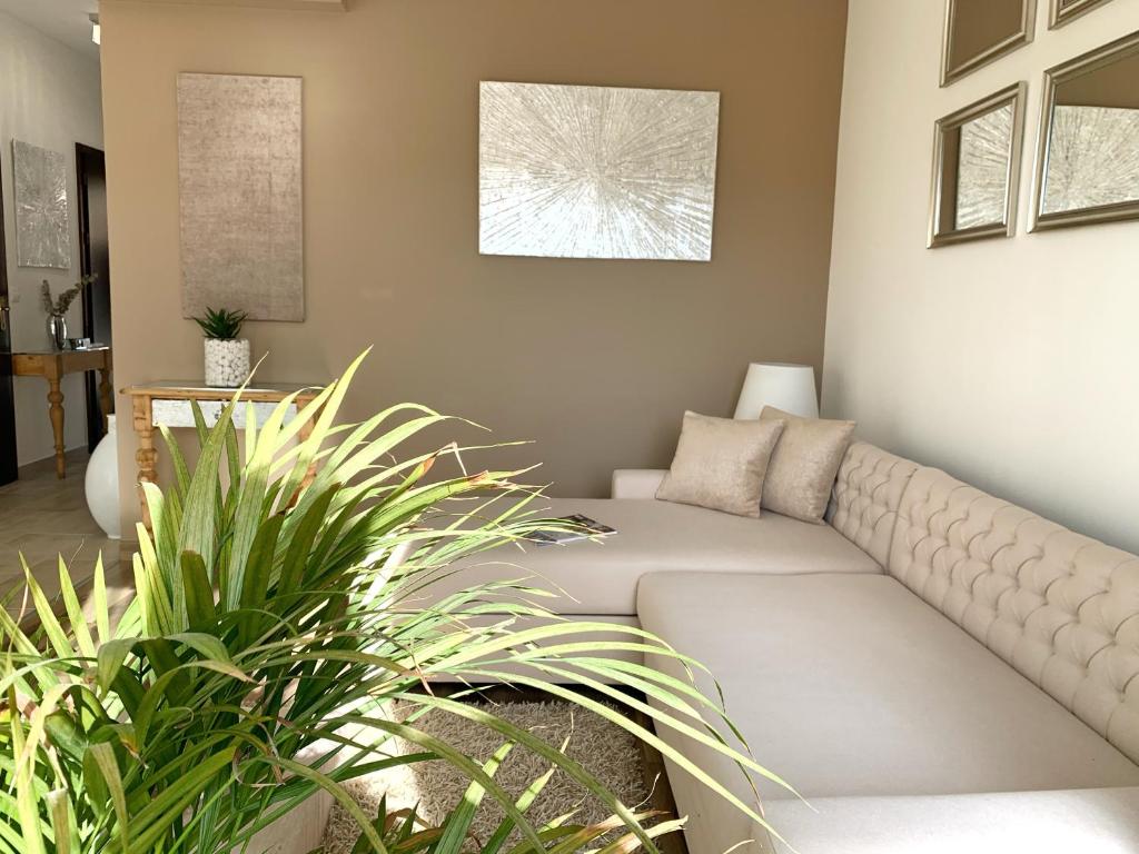 a living room with a couch and some plants at Panoráma apartman in Alsóörs